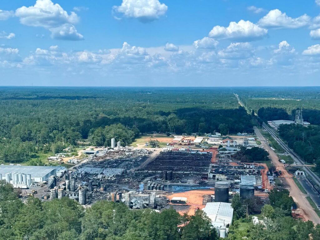 Aerial view of a burned facility surrounded by a woods