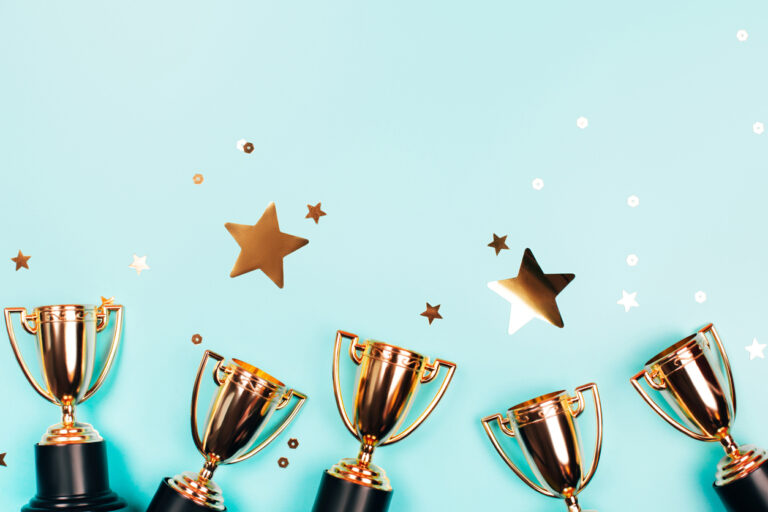 a line of gold trophy cups and stars