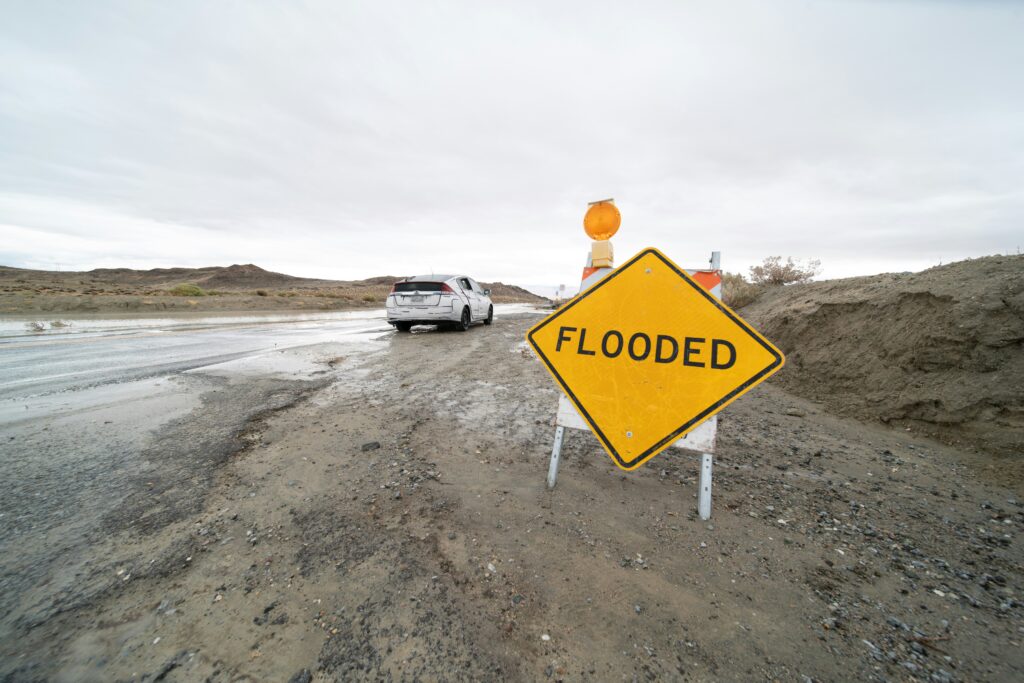 Wet road with sign that reads Flooded