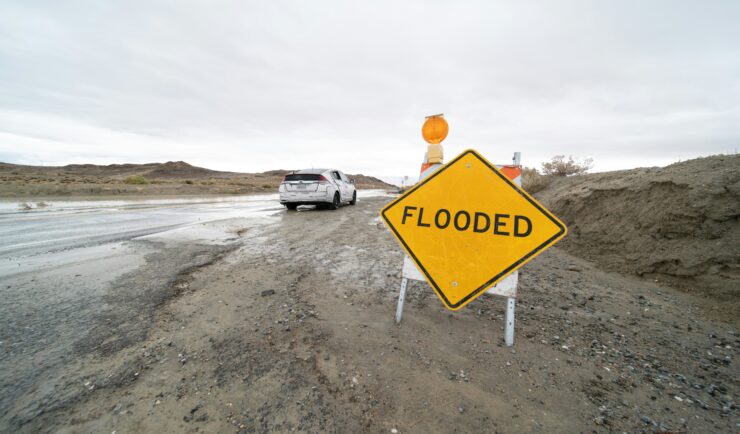 Wet road with sign that reads Flooded