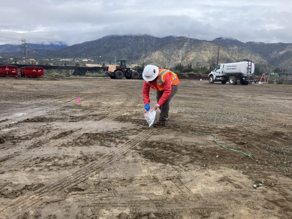 Worker collects sample of soil