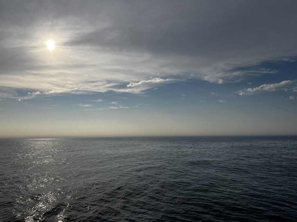 sun through clouds over open ocean