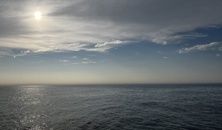 sun through clouds over open ocean