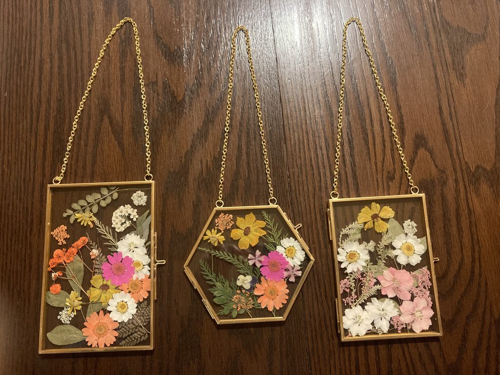Three pressed flower glass frames with chains.