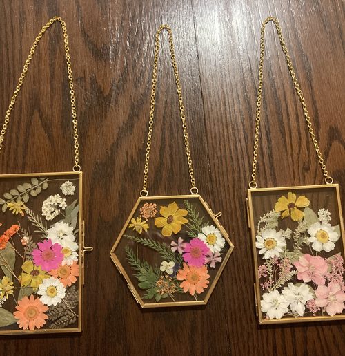 Three pressed flower glass frames with chains.